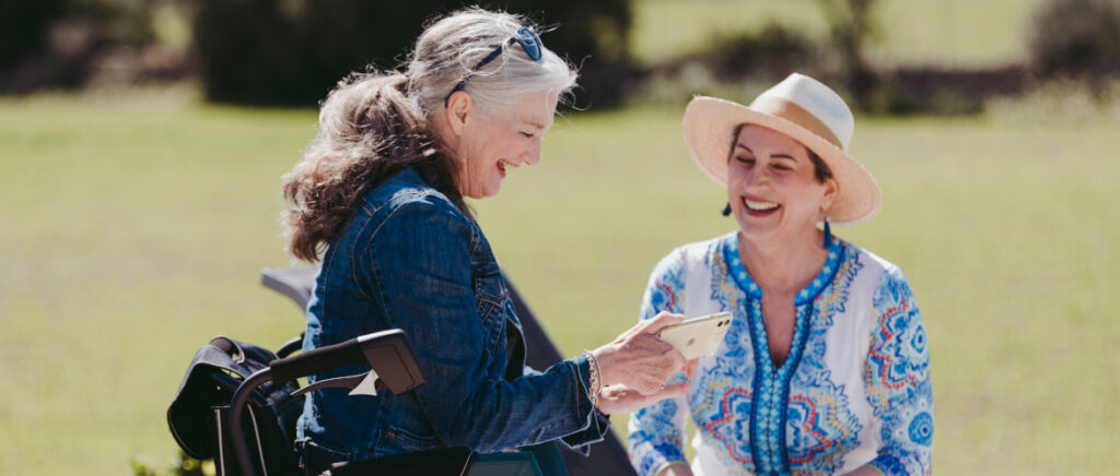 A woman sitting on a bench next to another woman