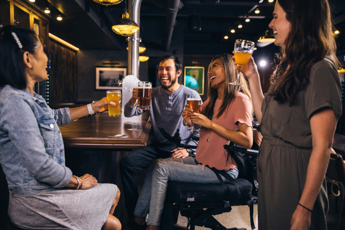 Mobility scooter user drinking in a pub with friends