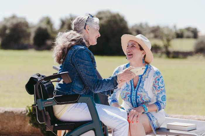 A woman on a mobility scooter talking to her friend in the park