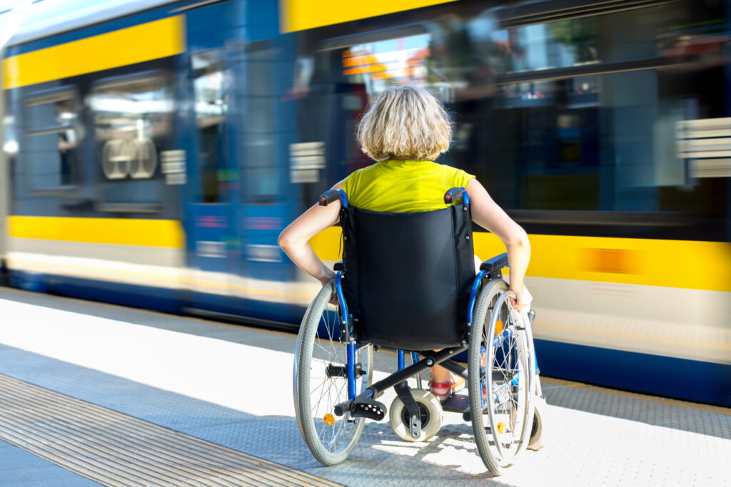 Lady taking a wheelchair onto a train