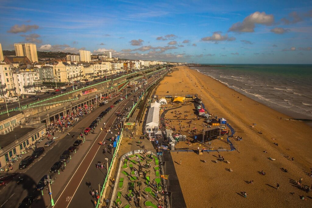A birds eye view of the sea, beach, promenade and buildings along Brighton seafront
