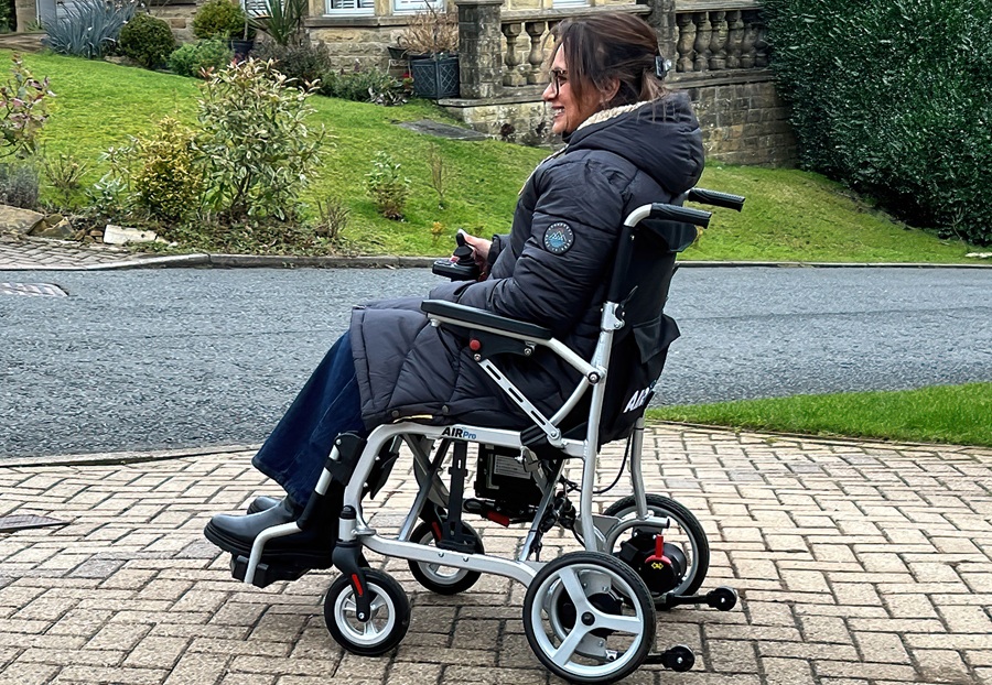 lady sitting in Air Pro powerchair on a paved driveway